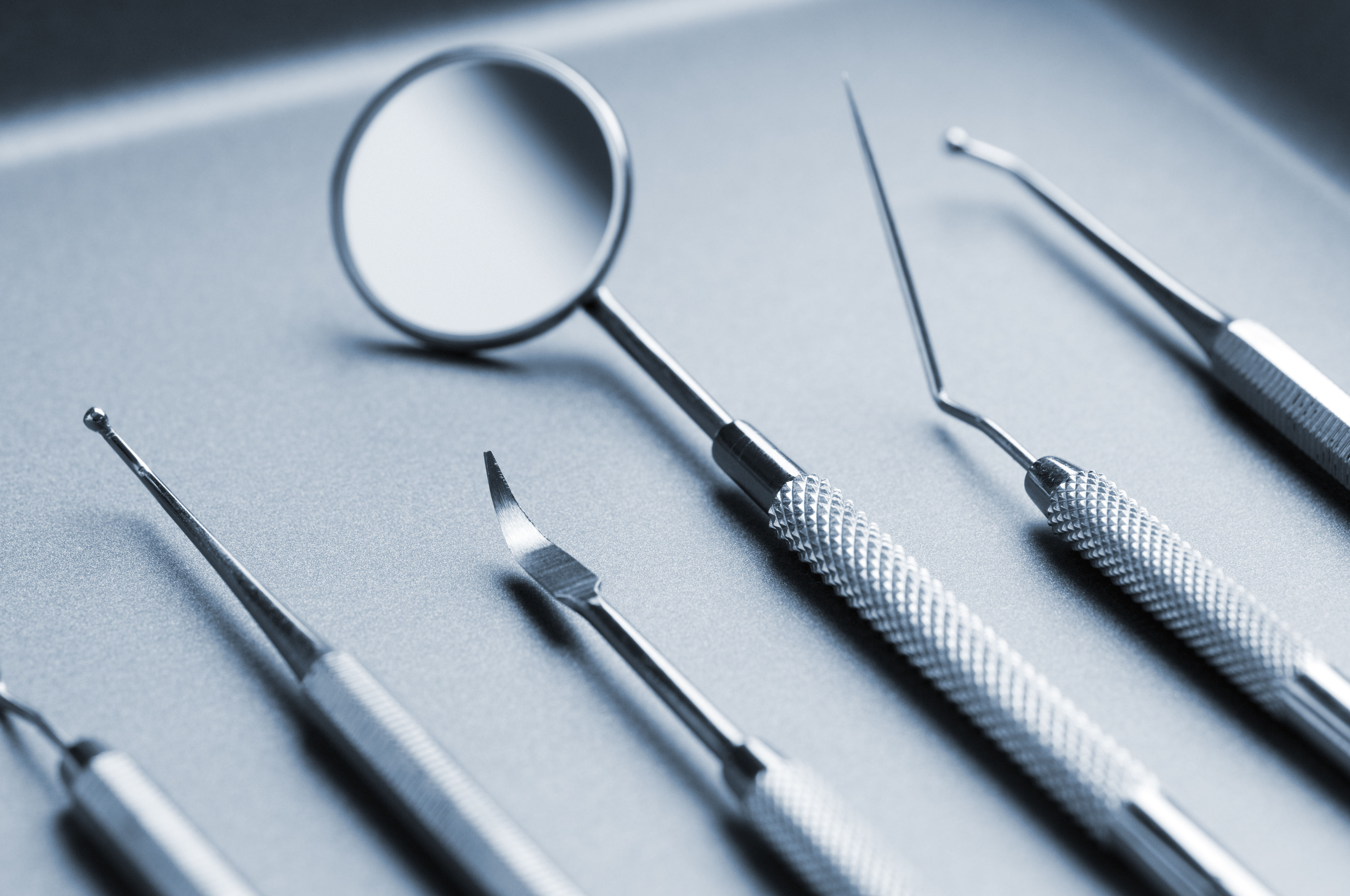 An array of dentil utensils on a silver tray